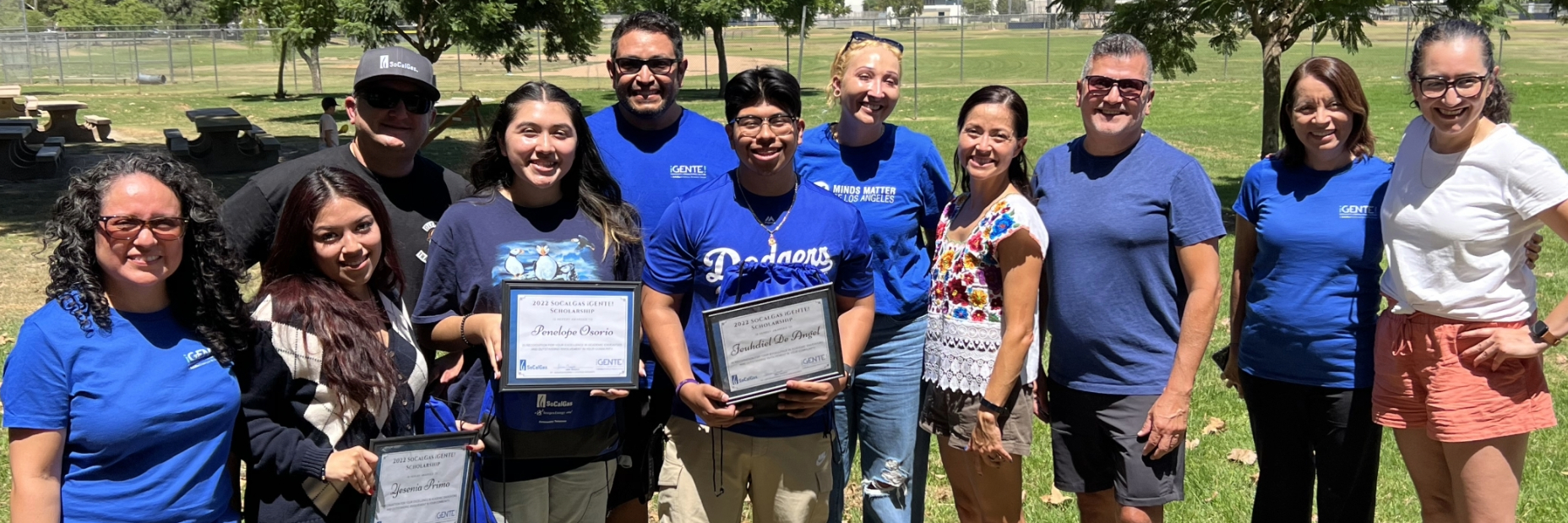 Students holding their scholarship awards with socalgas employees