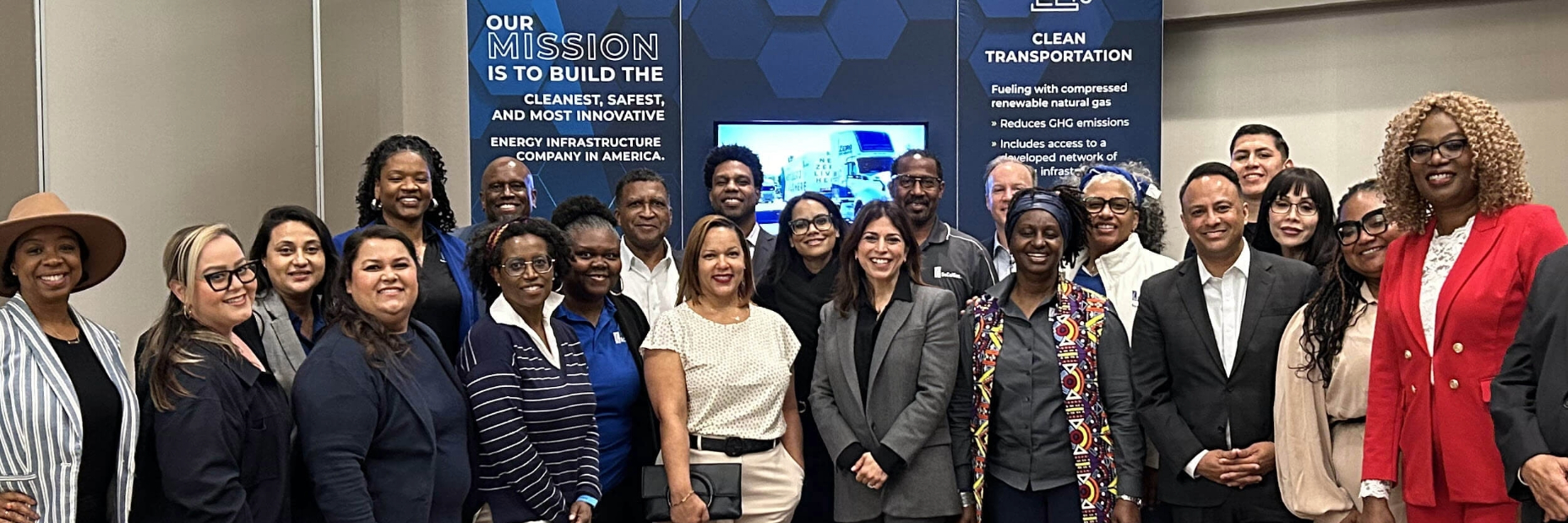 A group of people posing for a picture in front of the SoCalGas booth at the conference