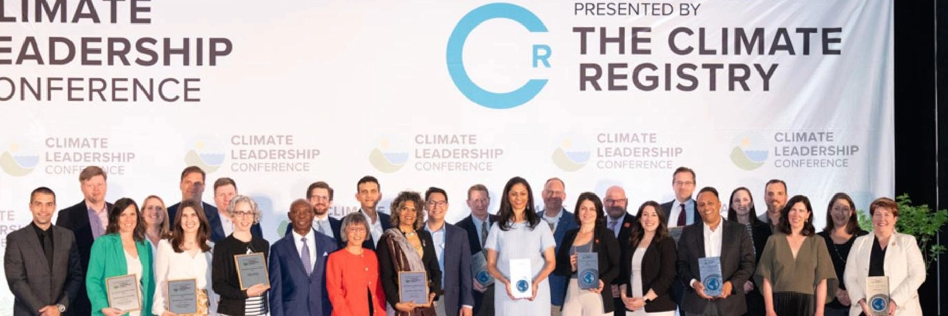 Award Winners on stage holding their awards at the Climate Registry Event