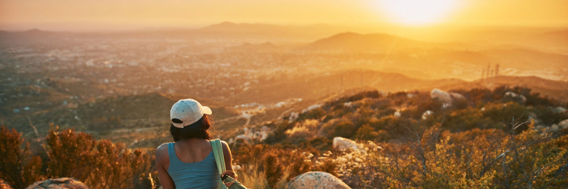 Woman Overlooking Sunny Mountains