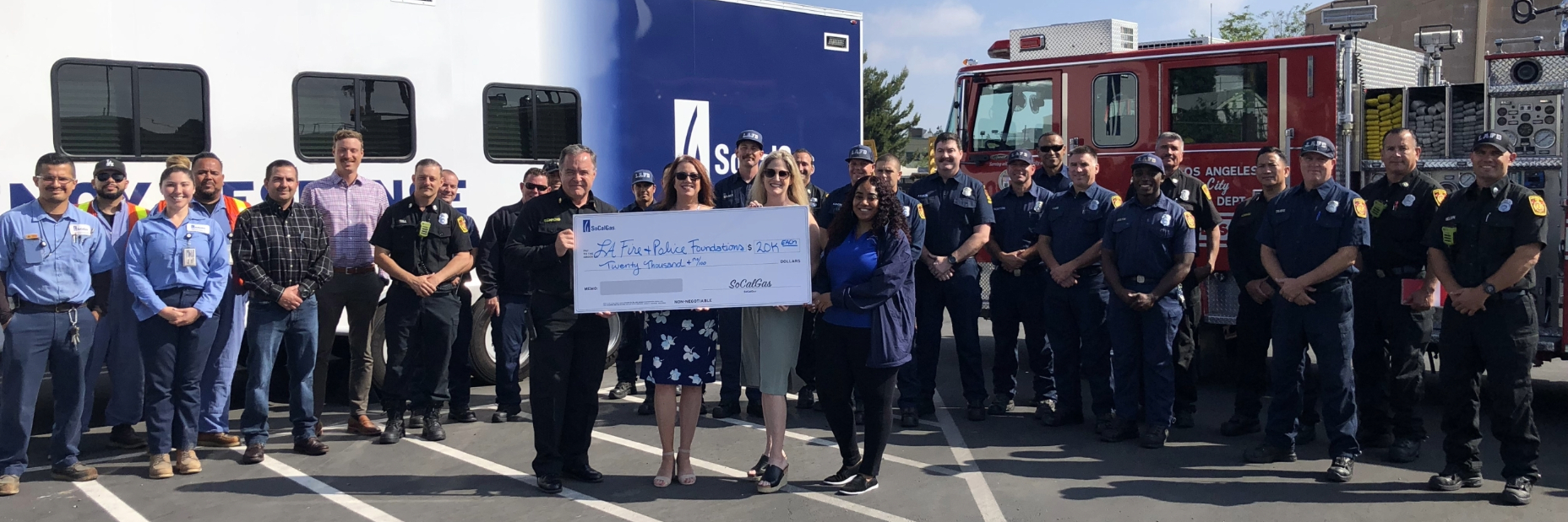 Police, Fire, and SoCalGas employees holding giant donation check