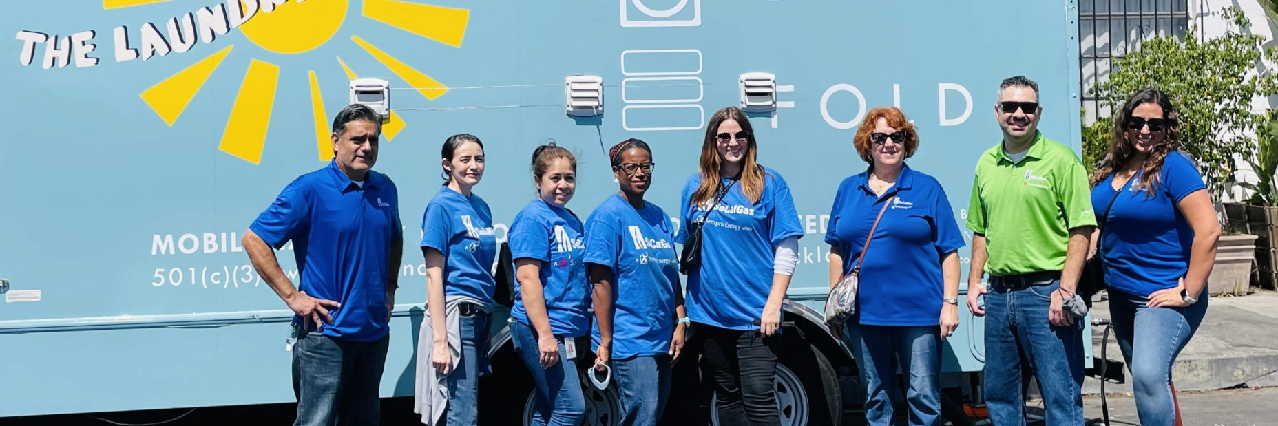 volunteers standing in front of a mobile laundry truck