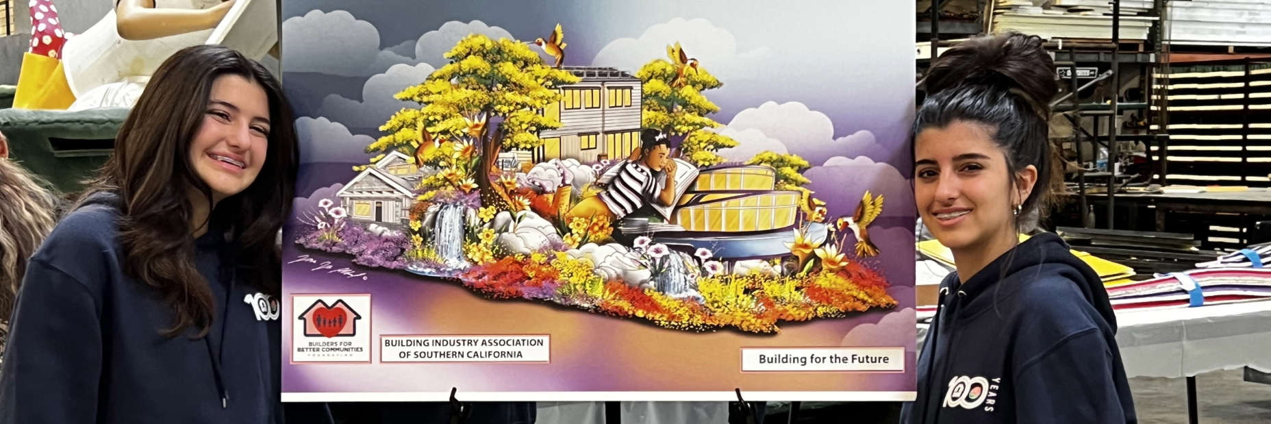 Two young students in front of float design drawing